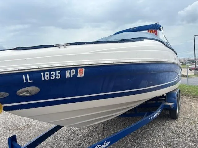 Slide: The Image of 2006 Rinker 232 Captiva Bowrider boat on trailer, blue and white exterior. - 32