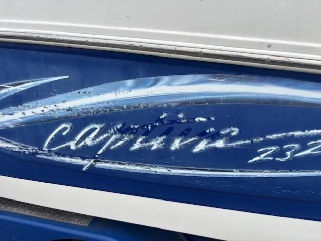 Slide: The Image of 2006 Rinker 232 Captiva Bowrider boat with blue and white detailing. - 34