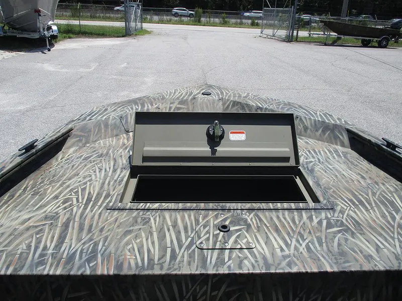 Slide: The Image of 2026 Tracker Grizzly 1648 SC boat with open storage compartment, camo pattern. - 11