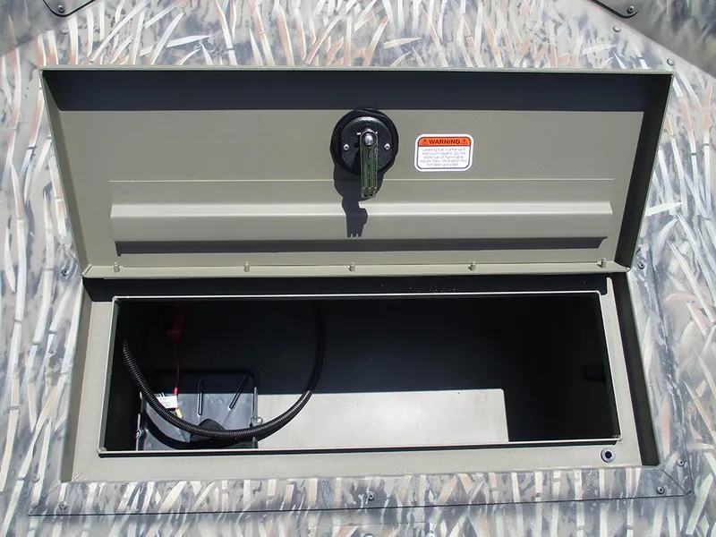 Slide: The Image of Open storage compartment in 2026 Tracker Grizzly 1648 SC boat, featuring camouflage design. - 12