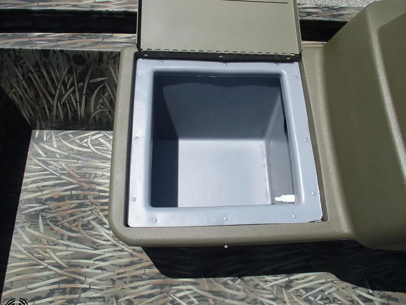 Slide: The Image of Open storage compartment in 2026 Tracker Grizzly 1648 SC boat, featuring camouflage design. - 15