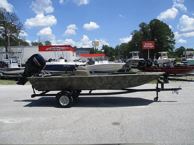 Slide: The Image of 2026 Tracker Grizzly 1648 SC boat on trailer, parked outdoors under a clear sky. - 6