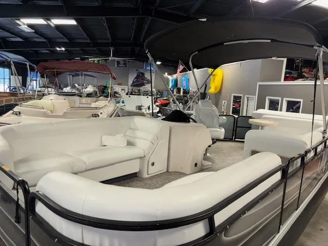 Slide: The Image of 2002 AquaPatio AP220R pontoon boat with white seating, displayed indoors. - 10