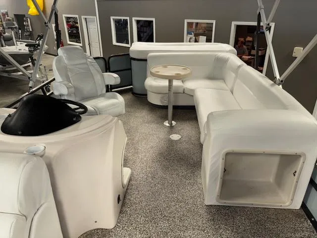 Slide: The Image of 2002 AquaPatio AP220R boat interior with white seating and steering console. - 14