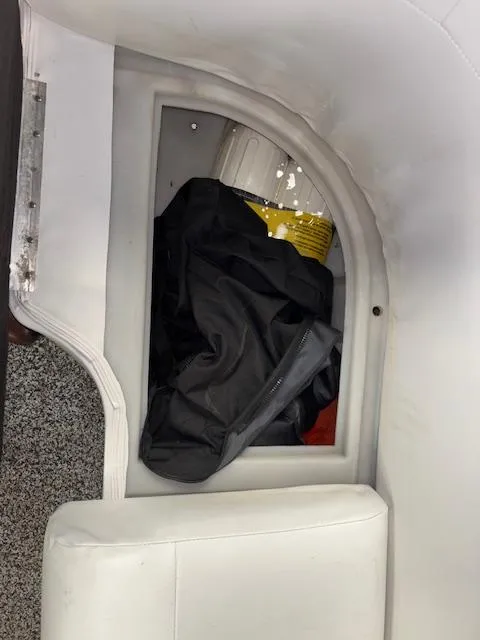 Slide: The Image of Storage compartment in 2002 AquaPatio AP220R boat with black cover and yellow bucket. - 24