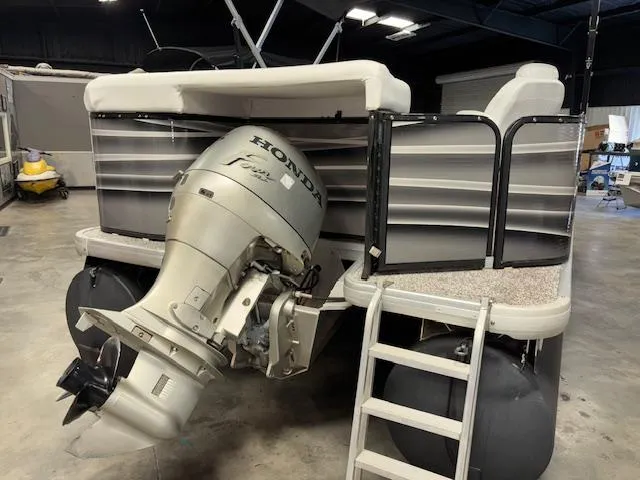 Slide: The Image of 2002 AquaPatio AP220R pontoon boat with Honda outboard motor in a garage. - 6