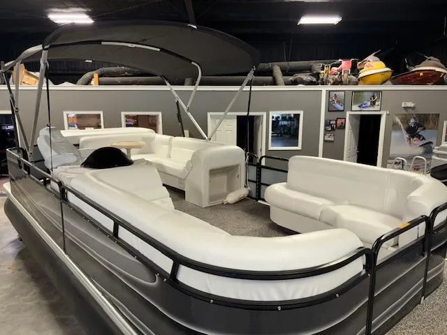 Slide: The Image of AquaPatio AP220R 2002 pontoon boat with white seating and canopy in showroom. - 8