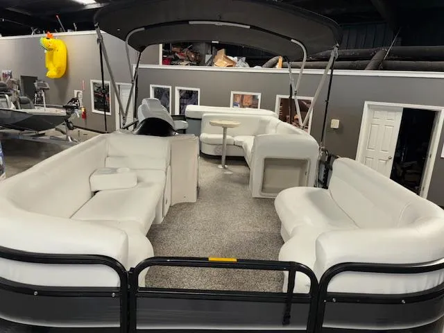 Slide: The Image of 2002 AquaPatio AP220R pontoon boat with spacious seating and canopy in a showroom. - 9