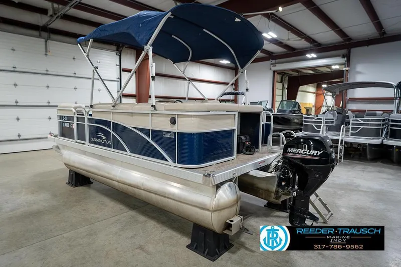 Slide: The Image of 2019 Bennington 18 SLV pontoon boat with Mercury outboard motor in indoor showroom. - 10
