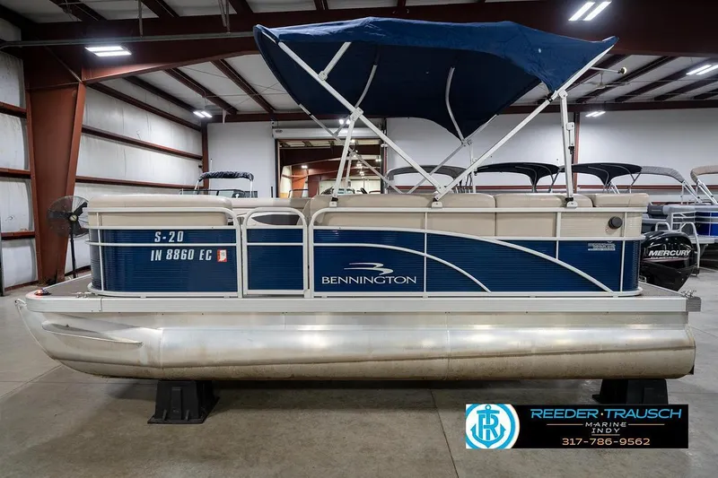 Slide: The Image of 2019 Bennington 18 SLV pontoon boat with blue canopy in indoor showroom. - 11