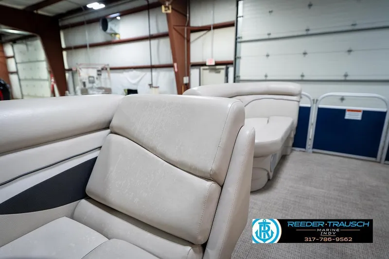 Slide: The Image of 2019 Bennington 18 SLV pontoon boat interior with beige seating in a showroom. - 21