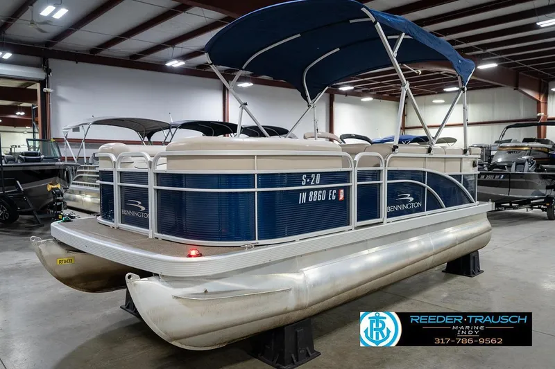 Slide: The Image of 2019 Bennington 18 SLV pontoon boat in indoor showroom with blue canopy. - 3