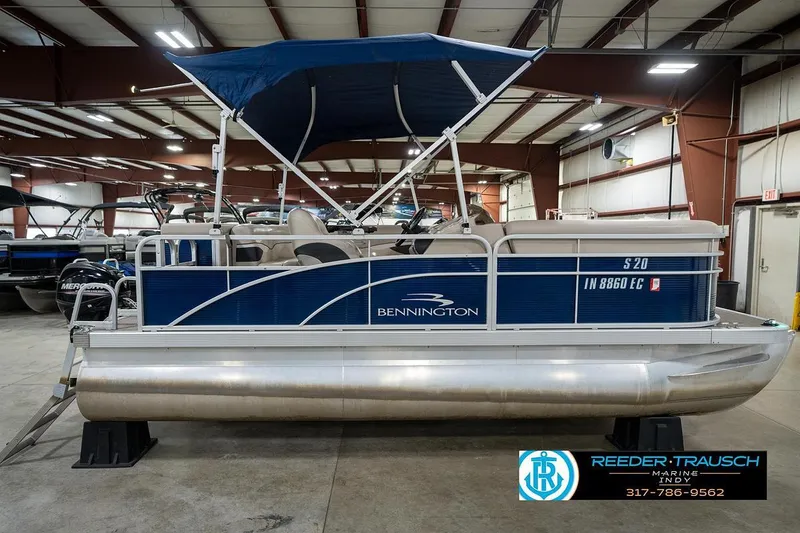 Slide: The Image of 2019 Bennington 18 SLV pontoon boat with blue canopy in indoor showroom. - 7
