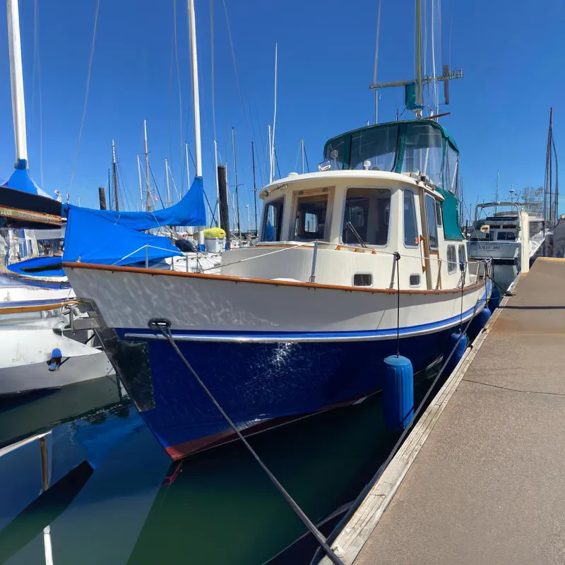The Image of 1986 Transpacific Marine Eagle boat docked at marina under clear blue sky. - 0