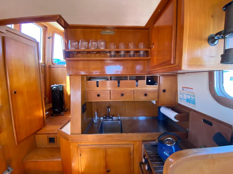 Slide: The Image of 1986 Transpacific Marine Eagle yacht kitchen with wooden cabinetry and stainless steel sink. - 11