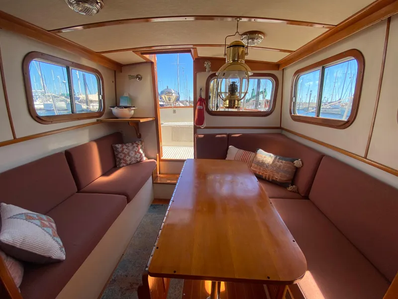 Slide: The Image of Interior of 1986 Transpacific Marine Eagle yacht with cozy seating and wooden table. - 13