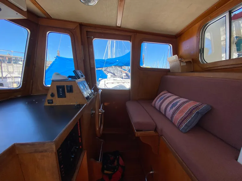 Slide: The Image of 1986 Transpacific Marine Eagle boat interior with wooden helm, cushioned seating, and nautical controls. - 16