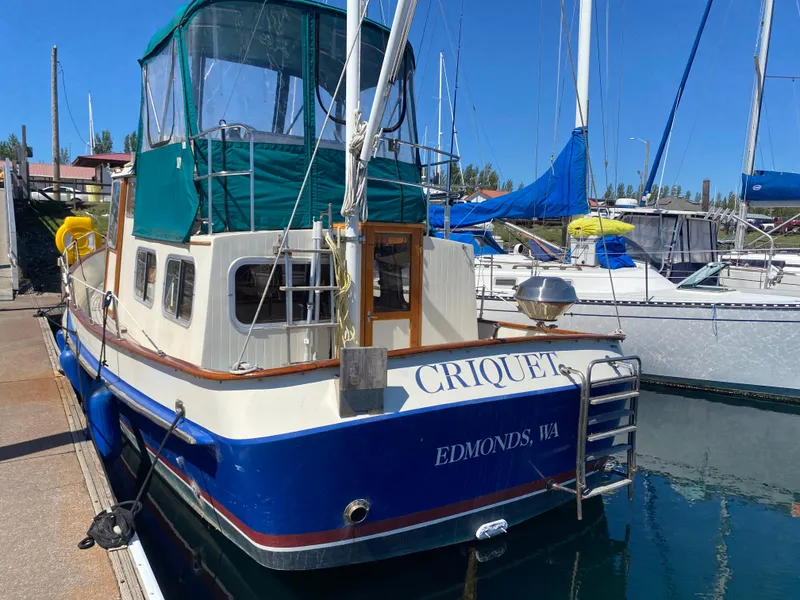 Slide: The Image of 1986 Transpacific Marine Eagle boat docked, featuring blue and white design with green canopy. - 2