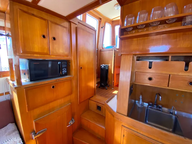 Slide: The Image of 1986 Transpacific Marine Eagle yacht interior with wooden cabinetry, microwave, and sink. - 24