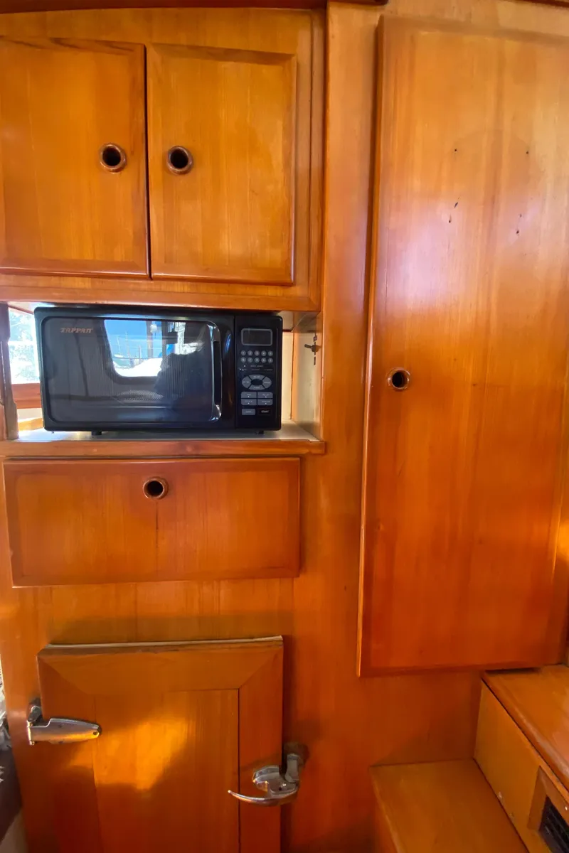 Slide: The Image of Wooden interior of 1986 Transpacific Marine Eagle with microwave and cabinets. - 25