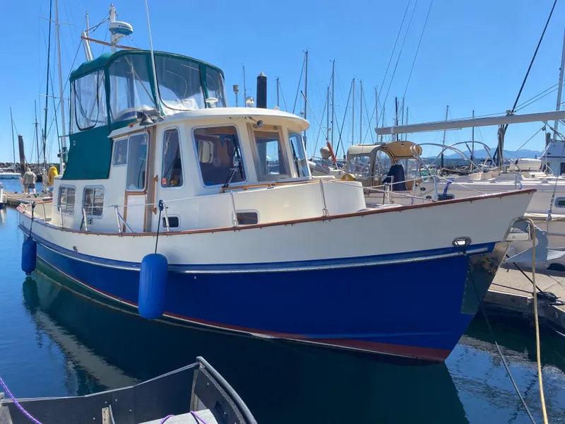Slide: The Image of 1986 Transpacific Marine Eagle boat docked in a marina, featuring a blue hull and green canopy. - 3