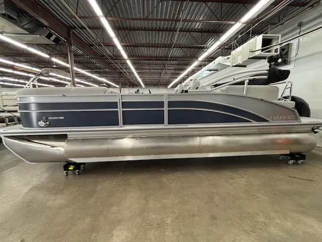 The Image of 2025 Harris Cruiser 230 CWDH pontoon boat in a showroom, side view. - 1
