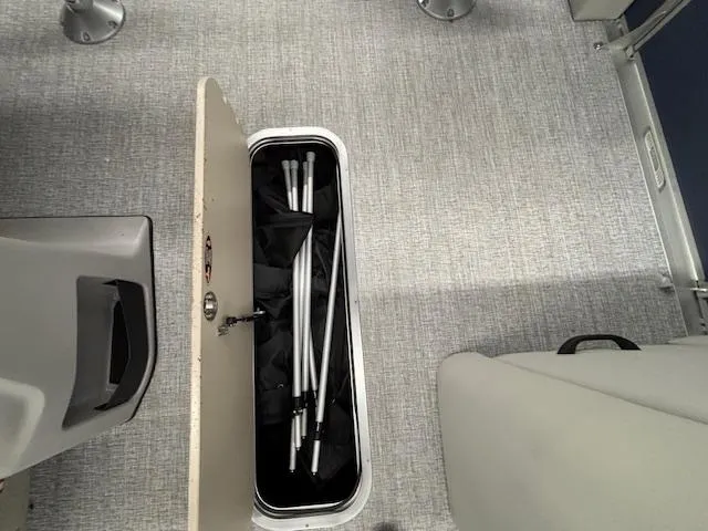 Slide: The Image of Storage compartment on 2025 Harris Cruiser 230 CWDH boat with metal poles inside. - 12