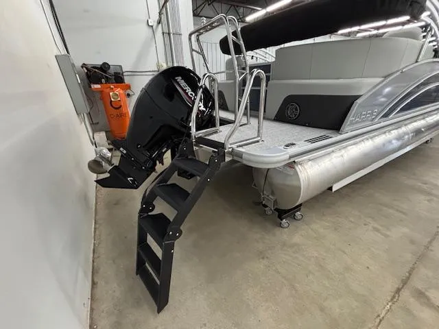 Slide: The Image of 2025 Harris Cruiser 230 CWDH pontoon boat with Mercury outboard motor and boarding ladder. - 18