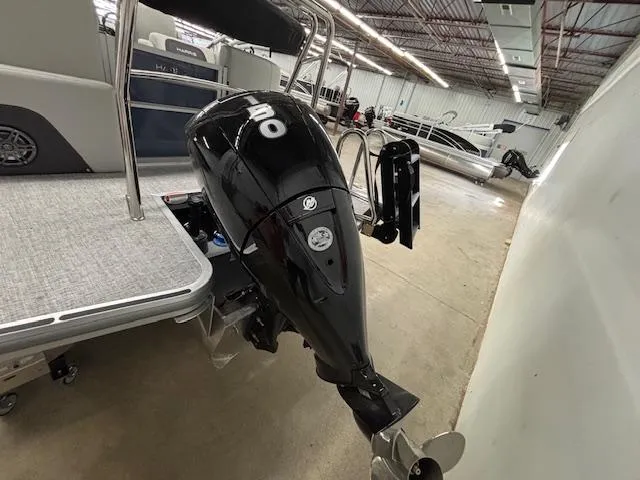 Slide: The Image of 2025 Harris Cruiser 230 CWDH boat with a powerful outboard motor in a showroom. - 20