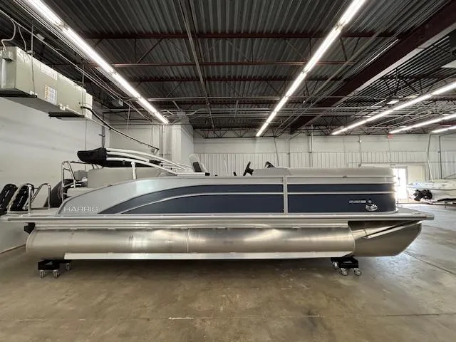 Slide: The Image of 2025 Harris Cruiser 230 CWDH pontoon boat in a spacious indoor storage facility. - 3