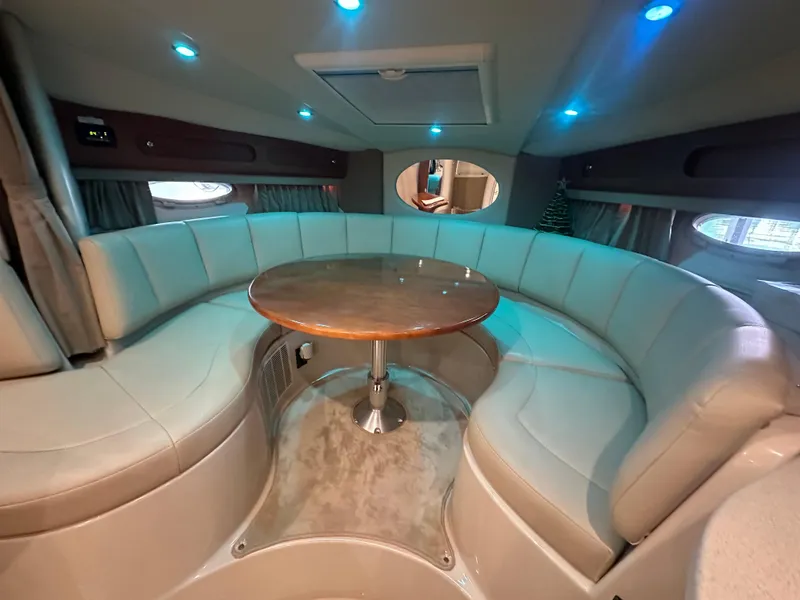 Slide: The Image of 2004 Chaparral Signature 330 interior with circular seating and wooden table. - 14
