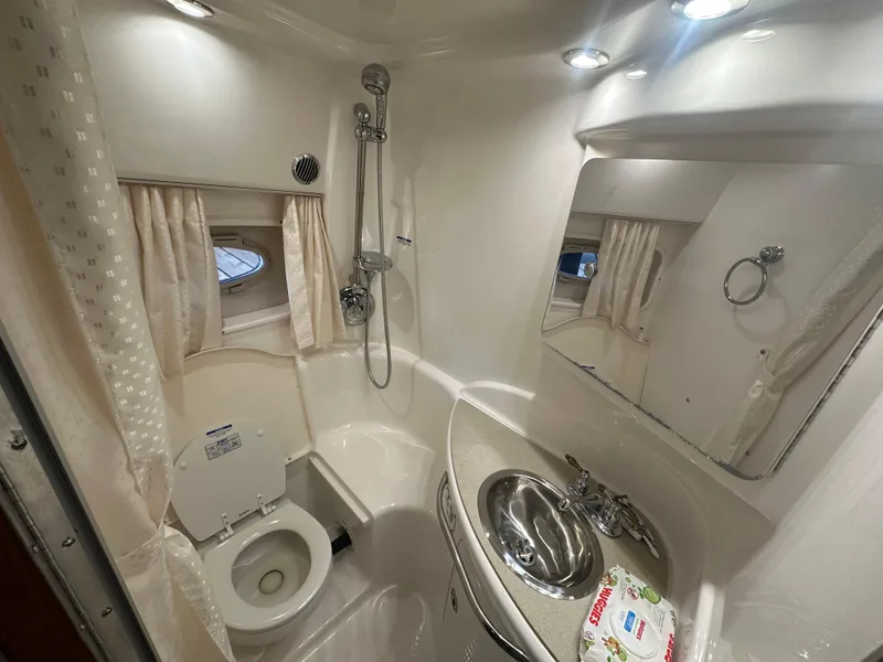 Slide: The Image of 2004 Chaparral Signature 330 bathroom with shower, sink, and toilet in compact, well-lit space. - 16