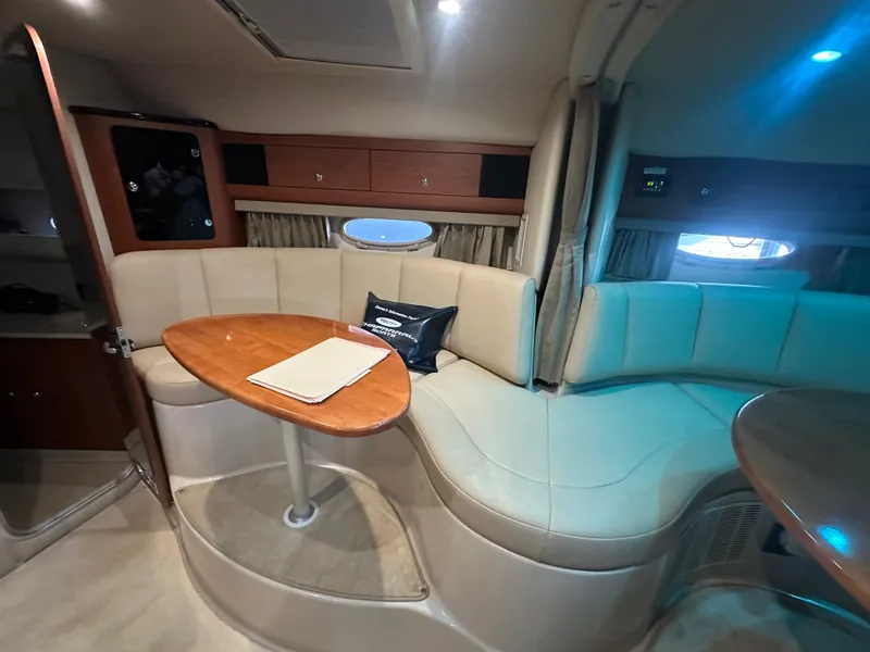 Slide: The Image of Interior of 2004 Chaparral Signature 330 yacht with beige seating and wooden table. - 19