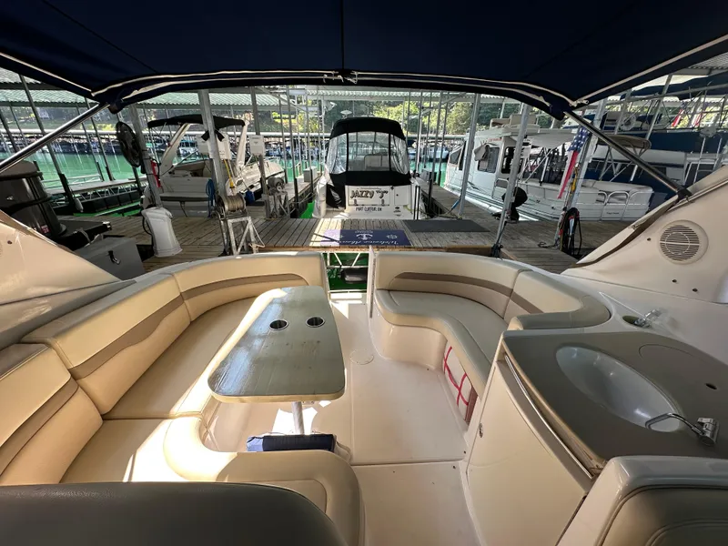Slide: The Image of 2004 Chaparral Signature 330 boat interior with seating, table, and sink at a marina. - 4