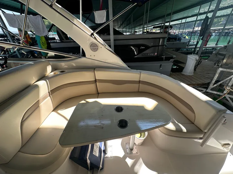 Slide: The Image of 2004 Chaparral Signature 330 boat interior with beige seating and table in a marina setting. - 7