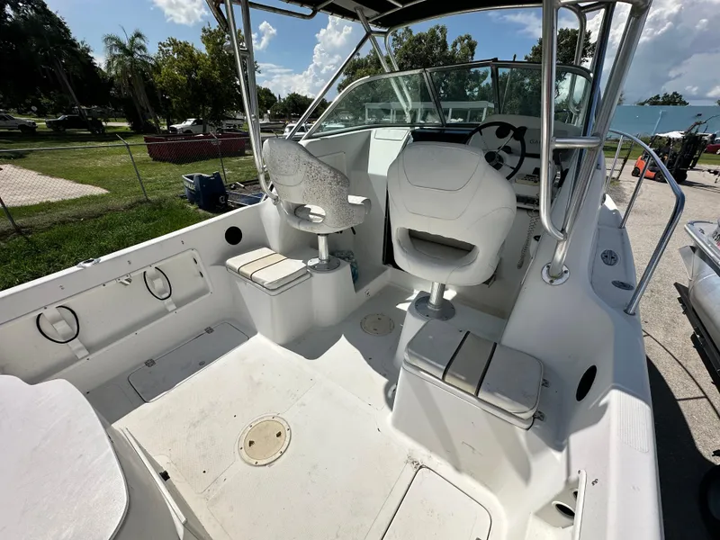 Slide: The Image of 2001 Sailfish 234 WAC boat interior with seating and steering wheel, parked outdoors. - 10
