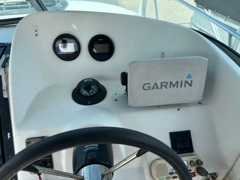 Slide: The Image of 2001 Sailfish 234 WAC boat dashboard with Garmin GPS, compass, and Yamaha gauges. - 13