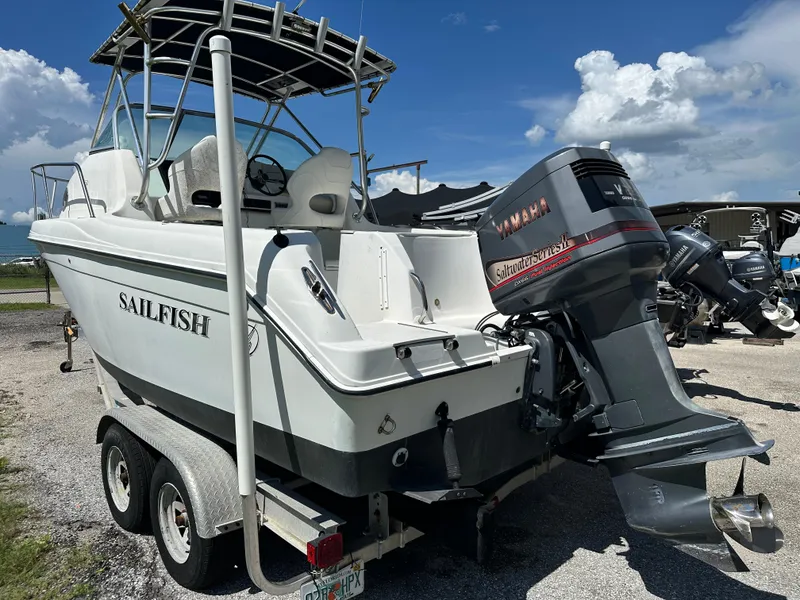 Slide: The Image of 2001 Sailfish 234 WAC boat with Yamaha outboard motor on trailer, parked outdoors. - 2