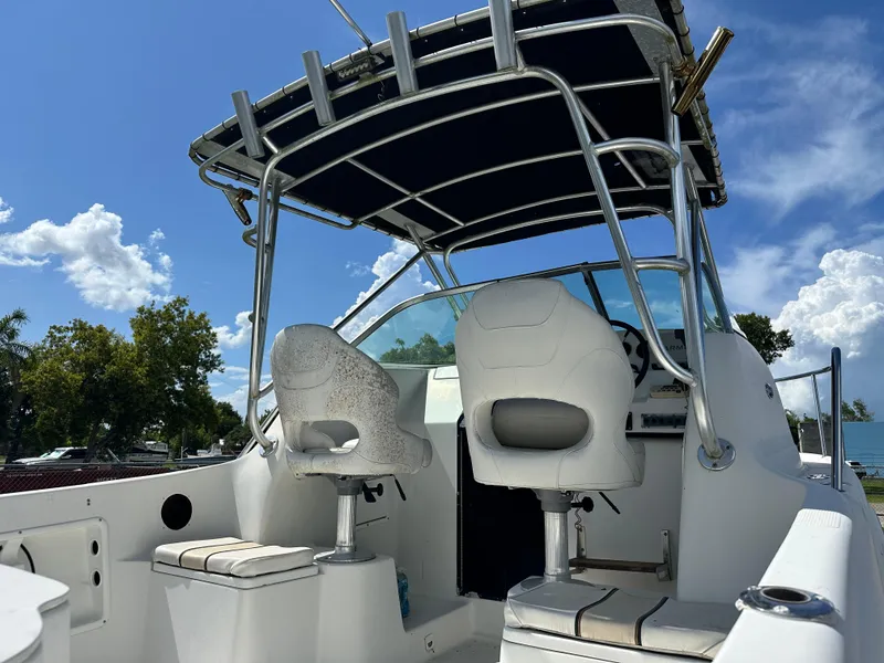 Slide: The Image of 2001 Sailfish 234 WAC boat interior with seating and canopy under a clear blue sky. - 4