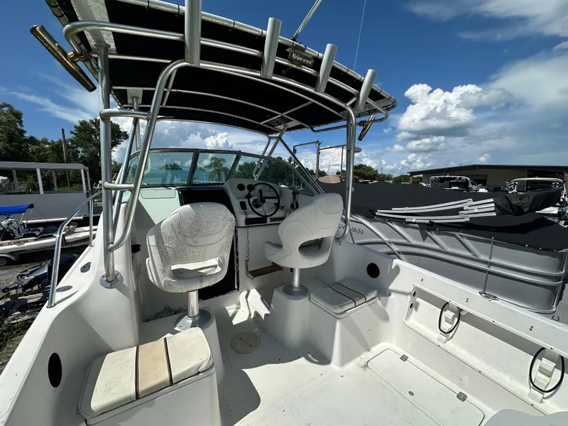 Slide: The Image of 2001 Sailfish 234 WAC boat interior with helm, seats, and canopy under a blue sky. - 9