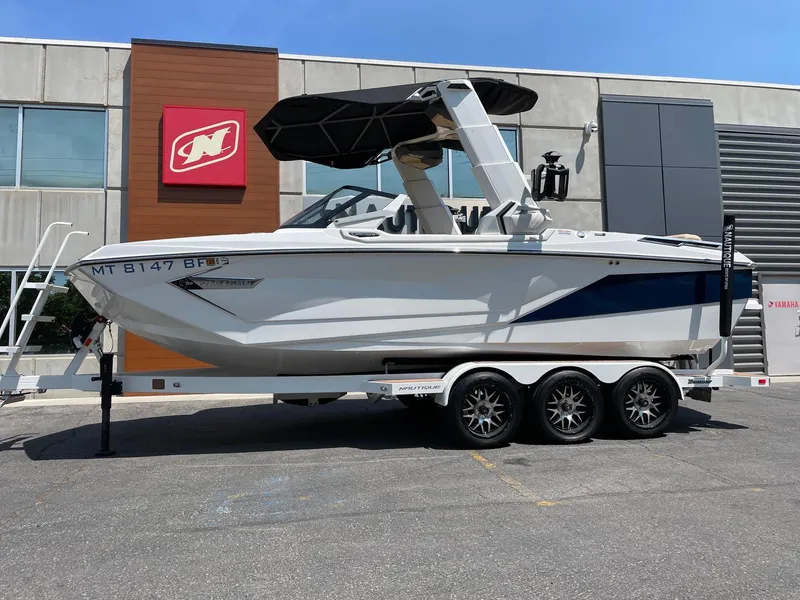 Slide: The Image of 2021 Nautique Super Air Nautique G23 Paragon boat on trailer, parked outside dealership. - 1
