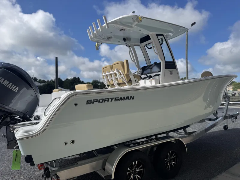 Slide: The Image of 2026 Sportsman Heritage 231 Center Console boat on trailer, featuring Yamaha engine, under blue sky. - 12