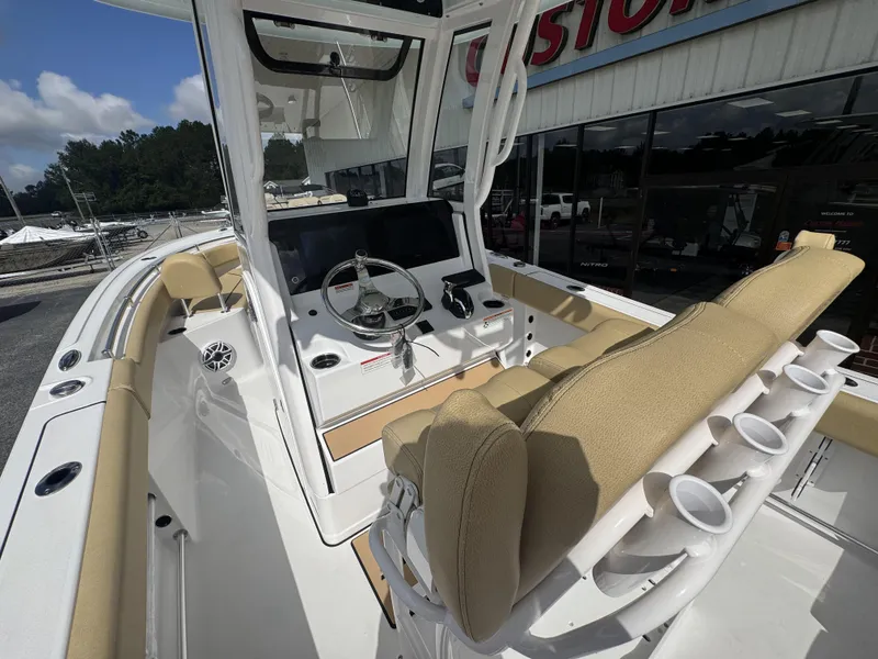 Slide: The Image of 2026 Sportsman Heritage 231 Center Console boat interior with beige seating and steering console. - 25