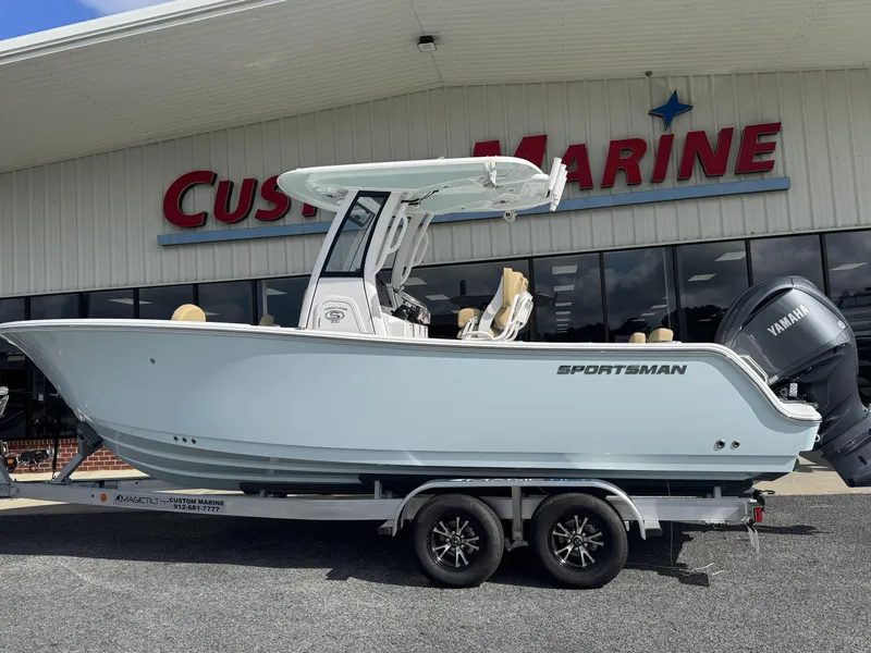 Slide: The Image of 2026 Sportsman Heritage 231 Center Console boat on trailer outside Custom Marine store. - 3