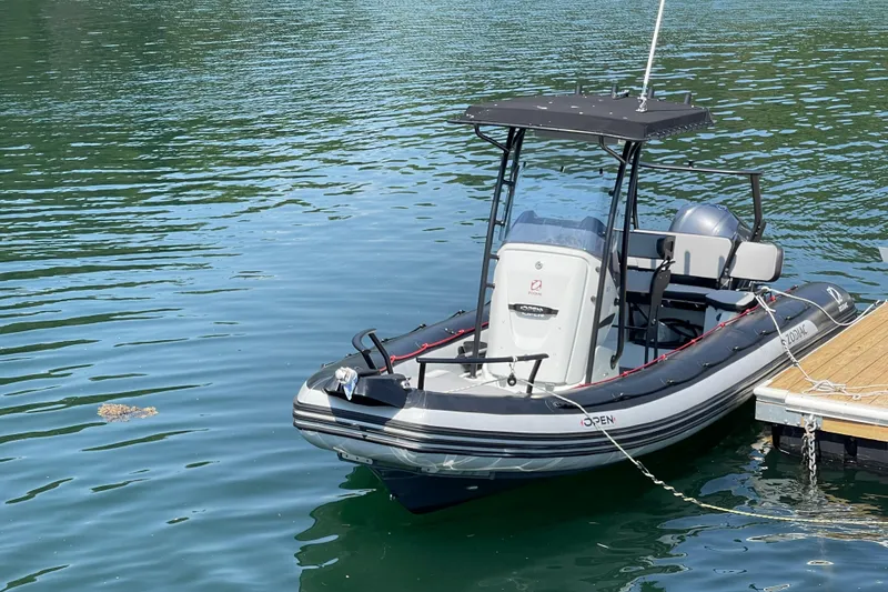 Slide: The Image of 2022 Zodiac Open 7 boat docked on calm water. - 10