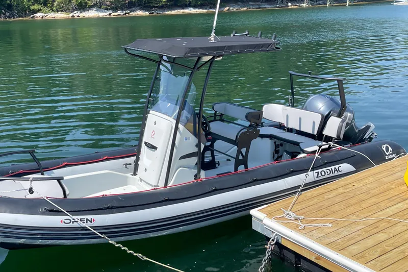 Slide: The Image of 2022 Zodiac Open 7 boat docked on calm water, featuring sleek design and modern equipment. - 12