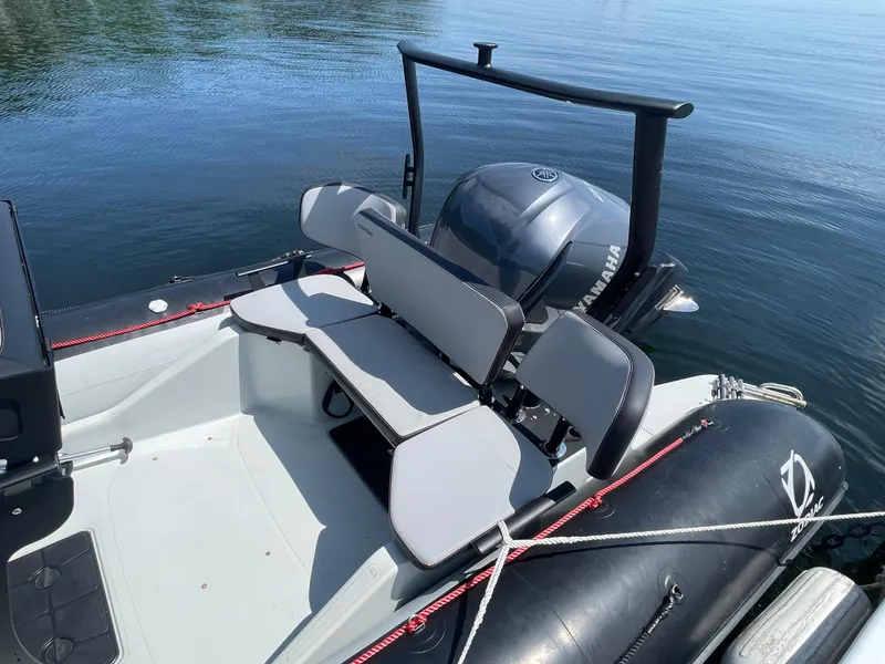 Slide: The Image of 2022 Zodiac Open 7 boat with Yamaha engine, docked on calm water. - 14