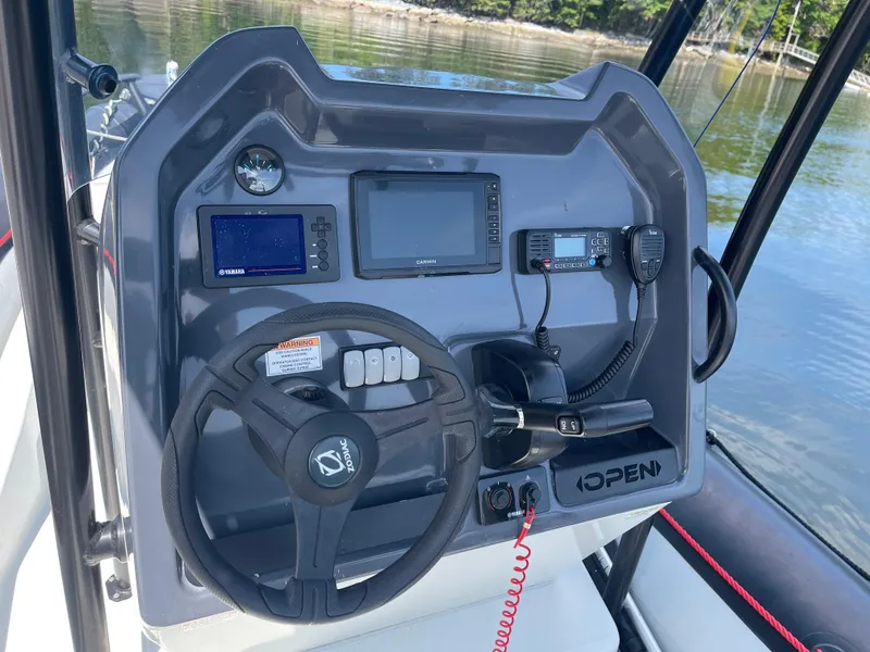 Slide: The Image of 2022 Zodiac Open 7 boat dashboard with steering wheel and navigation equipment. - 17
