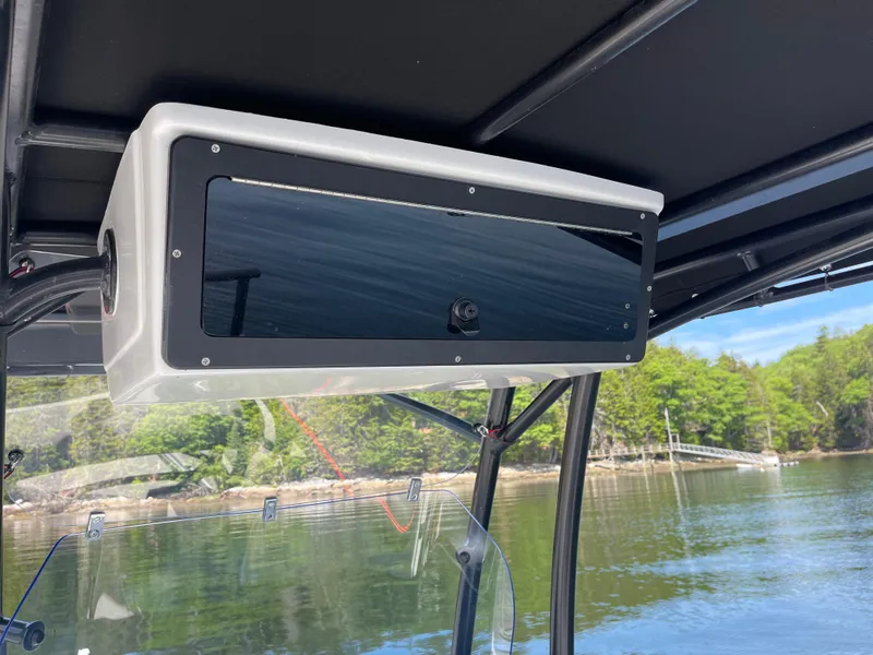 Slide: The Image of 2022 Zodiac Open 7 boat interior with storage compartment, scenic water and forest view. - 19