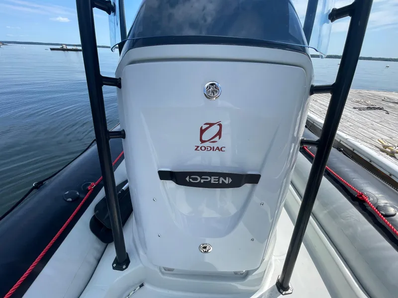 Slide: The Image of 2022 Zodiac Open 7 boat console with logo, docked by calm water. - 23